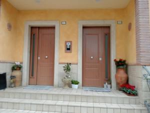 two doors on the side of a building with flowers at Casa Vacanze Giano in Antrodoco
