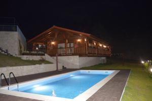 a swimming pool in front of a house at night at Chalé de Montanha in Vieira do Minho