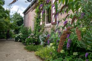 een stenen huis met bloemen aan de zijkant bij B&B Reveille in Kleve +24 foto's