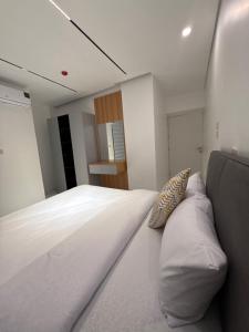 ein Schlafzimmer mit einem großen weißen Bett und Kissen in der Unterkunft Riva suites in Irbid + 16 Fotos