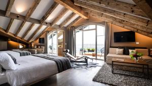 een slaapkamer met een groot bed en een woonkamer bij Alp Wellness Sport Hotel Panorama in Fai della Paganella