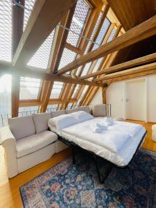 a large bed in a room with a couch at Schwarzwald Mauer Loft in Bräunlingen