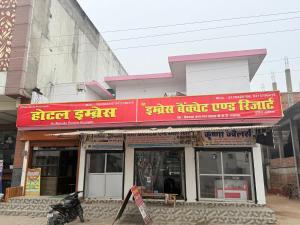 a building with a red sign on top of it at Hotel embrace in Bhauli