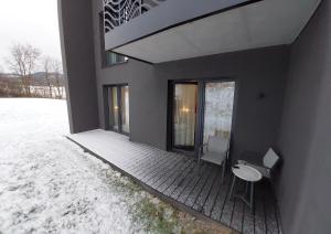 a house with two chairs and a table on a porch at Apart Hill in Sosnówka