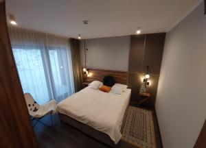 a bedroom with a bed and a chair and a mirror at Apart Hill in Sosnówka