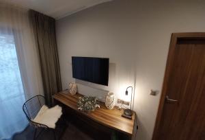 a room with a television on a wall at Apart Hill in Sosnówka