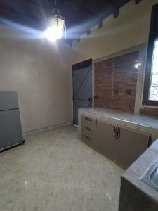 an empty room with a kitchen with a large door at Camels house apartment in Adrouine
