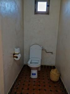 a small bathroom with a toilet and a window at Camels house apartment in Adrouine +15 photos