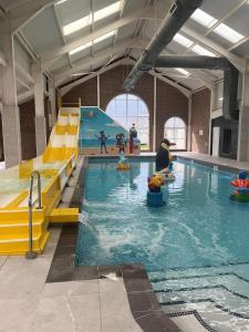 een groot zwembad met een glijbaan in een gebouw bij Lyon's Robin Hood Rhyl 8 Berth Caravan in Rhyl