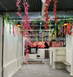 a room with flowers hanging from the ceiling at Tridev Hills in Ujjain