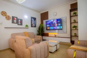 a living room with couches and a flat screen tv at SeyniKe 2BR Apartment - Nyali - AC, WiFi - Parking in Mombasa