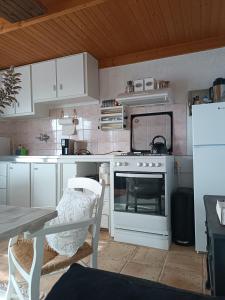 una cucina con piano cottura bianco e tavolo di Epavlis a Mirsíni