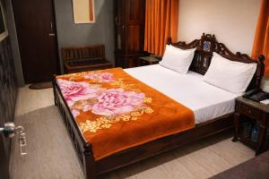 a bedroom with a bed with a blanket on it at Hotel Sudarshan By Nath Bliss - Near Shrinathji Temple Just 2 Mins Walk in Nāthdwāra