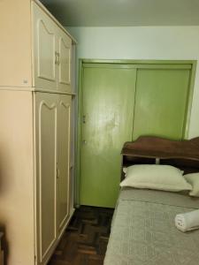 a bedroom with a bed and a green wall at Quarto privado Brusque in Brusque