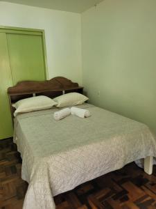 a bedroom with a bed with two towels on it at Quarto privado Brusque in Brusque
