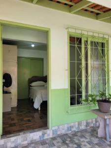 a room with a bed and a room with a window at Quarto privado Brusque in Brusque