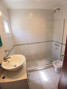 a bathroom with a shower and a sink and a toilet at Casa Parque Playa in Necochea +14 photos