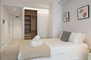 a white room with a bed and a book shelf at Genesis-Loft San Enrique 14 in Madrid