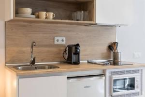 a kitchen with a sink and a microwave at Genesis-Loft San Enrique 14 in Madrid +8 photos
