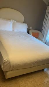 a large bed with white sheets and pillows at Santellone Lifestyle Resort in Brescia