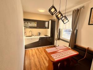 a small kitchen with a table in a room at Chata POD HOUBOVÝM VRCHEM in Horní Planá +17 photos