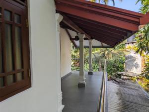 a porch of a house with a red awning at Villa 505 Induruwa in Induruwa