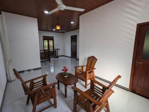 a room with chairs and a table and a ceiling fan at Villa 505 Induruwa in Induruwa