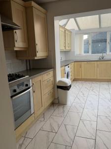 eine Küche mit Holzschränken und Fliesenboden in der Unterkunft Nightingale in Lower Darwen