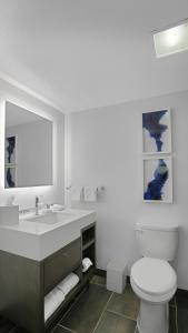 ein Badezimmer mit Waschbecken, Toilette und Spiegel in der Unterkunft MetLife Stadium Hotel for Matchdays Game Shuttle in Secaucus