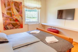 a bedroom with a bed with two towels on it at Private Pool Villa with Garden & Nature by Destination GREEN Croatia in Pregrada +18 photos