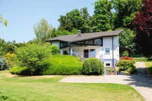 a white house with a porch and a yard at Private Pool Villa with Garden & Nature by Destination GREEN Croatia in Pregrada