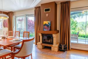 a dining room with a table and a fireplace at Private Pool Villa with Garden & Nature by Destination GREEN Croatia in Pregrada