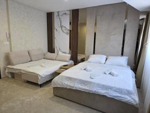 two beds in a hotel room with towels on them at PETKOV5KI LuxuryApartment in Skopje +4 photos