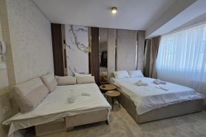 a hotel room with two beds and a couch at PETKOV5KI LuxuryApartment in Skopje