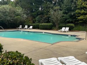 a swimming pool with lounge chairs next to at Lovely 2BR 3BA Condo in Auburn