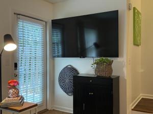 a living room with a television on a wall at Lovely 2BR 3BA Condo in Auburn