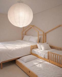 2 Betten in einem Zimmer mit Kronleuchter in der Unterkunft Madison Park Apartments by Host Jess in Jakarta