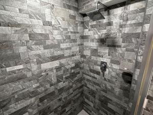 a bathroom with a shower with a stone wall at Steps from the Historic Center & Malecón in Campeche