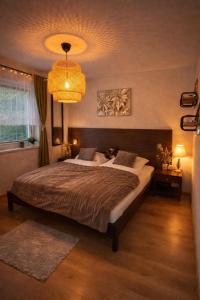 een slaapkamer met een groot bed en een kroonluchter bij Donovaly Apartman Galileo in Donovaly