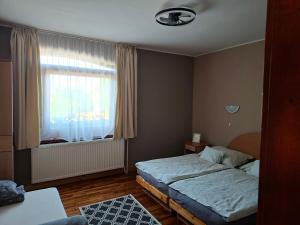 una piccola camera da letto con un letto e una finestra di SUNFISH Apartman a Balatonszárszó