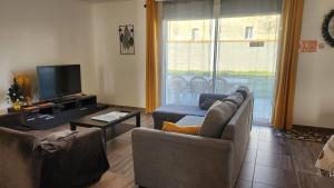 a living room with a couch and a tv and a table at Maison proche Futuroscope in Chasseneuil-du-Poitou +35 photos