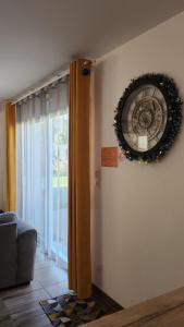a clock on the wall in a room with a window at Maison proche Futuroscope in Chasseneuil-du-Poitou