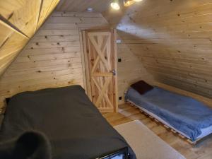 a room with a bed in a wooden cabin at Juraszówka in Kamesznica
