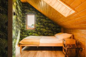 a bed in a room with a green wall at Agroturystyka Monte Luna - Domki in Czarnów