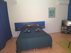 a bedroom with a bed with two pairs of shoes on it at Studio Kerbignon, Piscine privée in Case-Pilote +18 photos