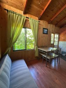 Zimmer mit einem Bett und einem Tisch in einer Hütte in der Unterkunft Cabañas el rincón de Colbún in Colbún + 32 Fotos