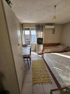 a bedroom with a bed and a desk and a window at Villa Lira in Pavel Banya