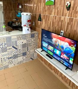 een flatscreen-tv op een aanrecht in een keuken bij Green House Cumbuco in Caucaia +8 foto's