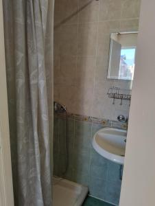 a bathroom with a shower curtain and a sink at Villa Lira in Pavel Banya +4 photos