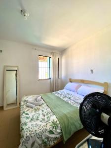 een slaapkamer met een bed, een raam en een ventilator bij Green House Cumbuco in Caucaia